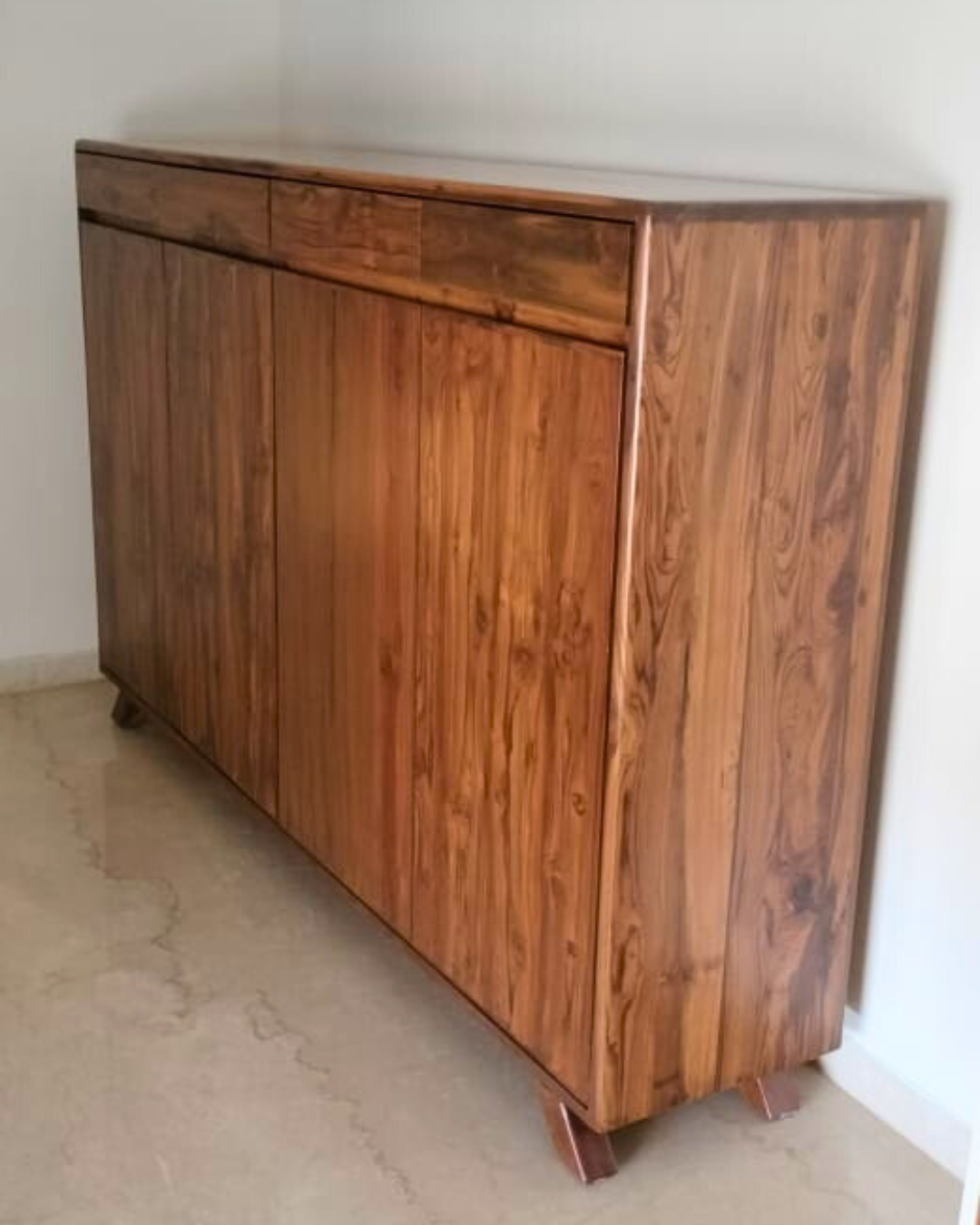 Wooden teakwood shoe cabinet against a white wall