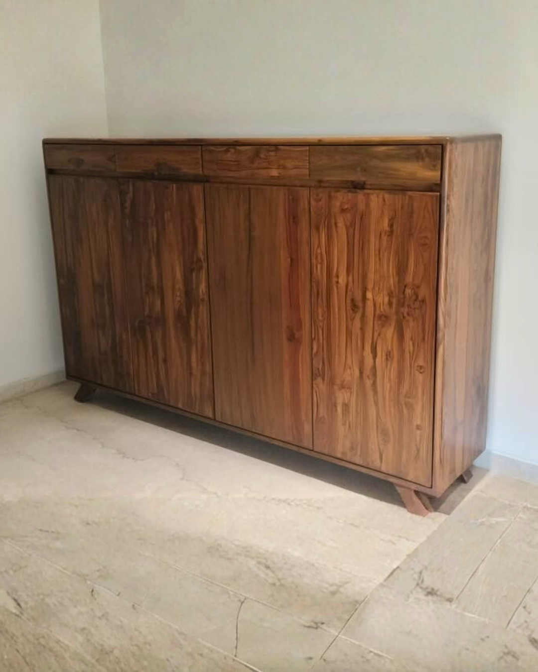 Wooden teakwood shoe cabinet against a white wall